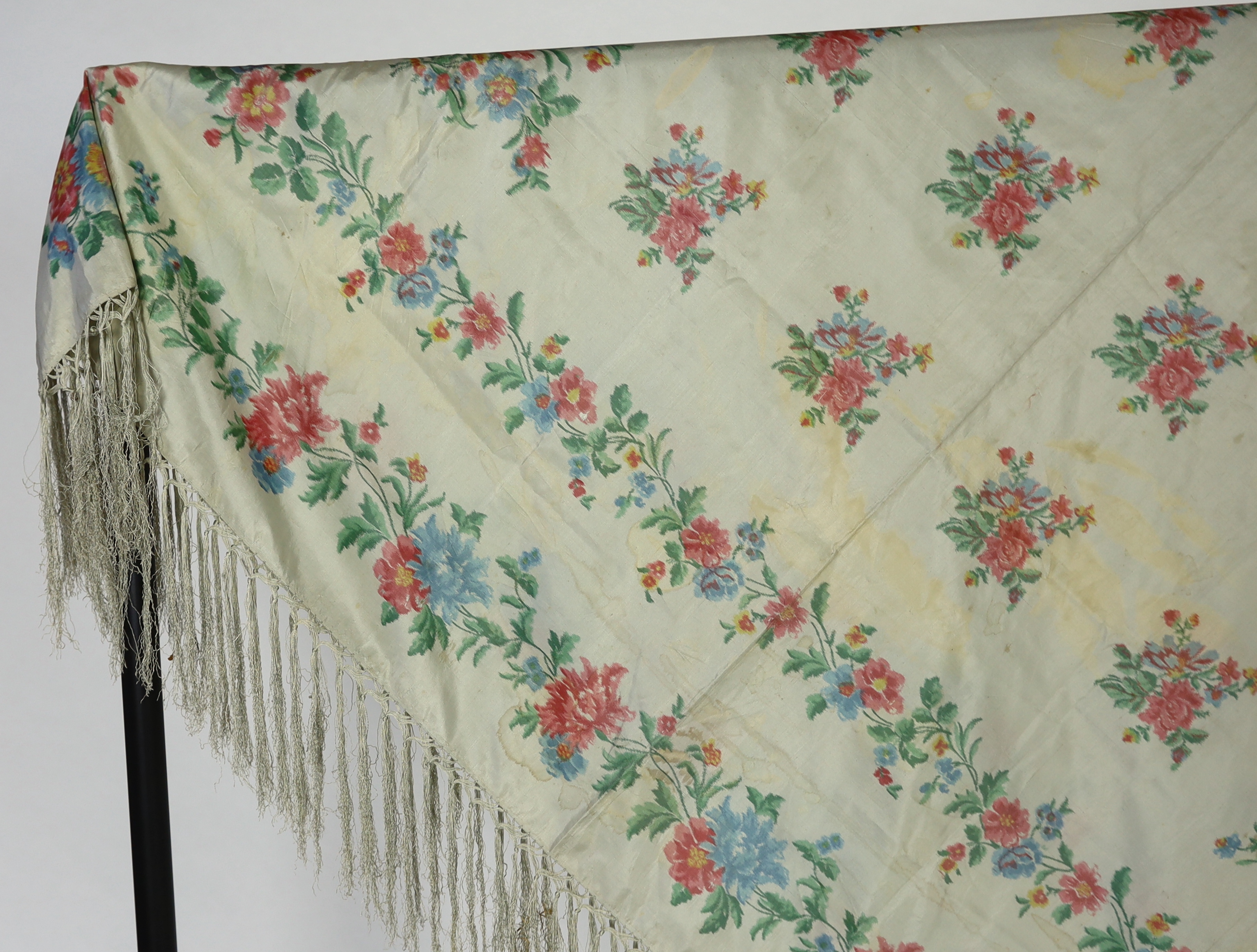 A French silk shawl, c.1800-1840, of a type modelled by Madame Recamier in the painting by François Gerard, printed on the warp thread into a rose pattern, with long fringing, 174 x 170cm